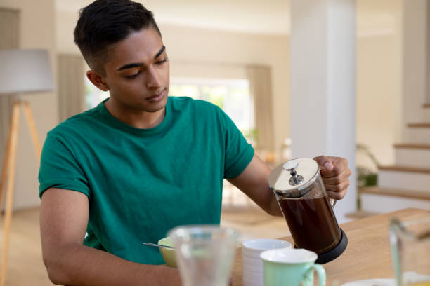 istock Mixed race man sitting at table and eating breakfast 1307866393