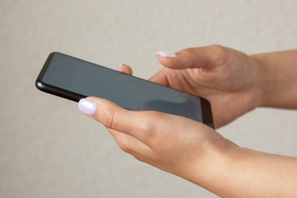 istock girl holds smartphone in hands on a light background 1307867241
