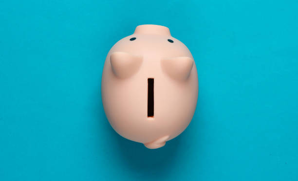 istock Piggy bank on blue background. Minimalistic studio shot. Overhead view. Flat lay. 1307867271