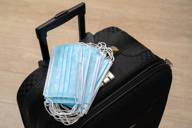 istock Medical masks on a black suitcase. 1307868520