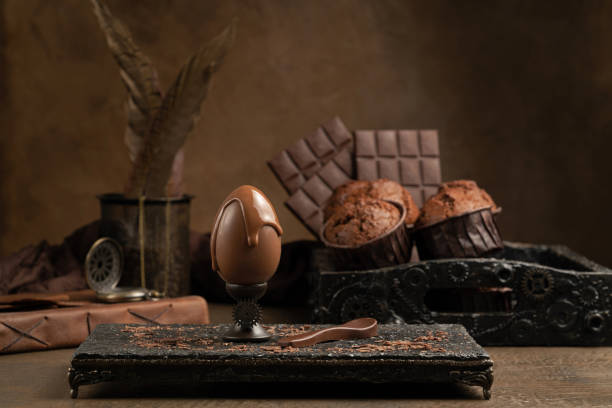 Milk Chocolate Egg with Drops on a Eggcup Milk Chocolate Egg with Drops on a Eggcup on a Brown Background. Chocolate Day Concept. Shallow Depth of Field, Monochrome temptation photos stock pictures, royalty-free photos & images