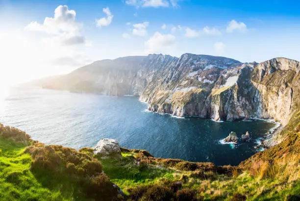 Beautiful Sea view at Slieve League in Ireland Donegal. Great Coast with Rocks and Cliffs at the Background. Sunset and Sunbeams on the road.