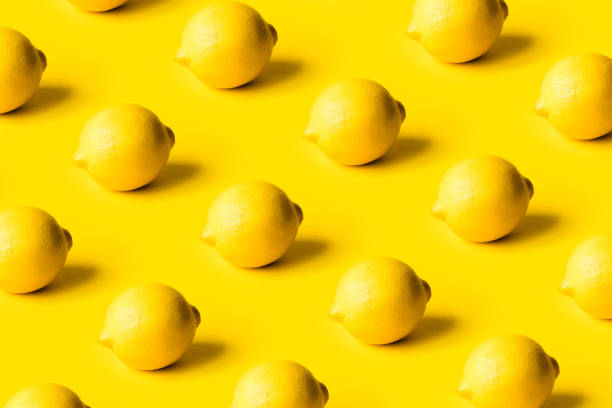 istock Pattern of ripe lemons on a yellow background. 1307874807