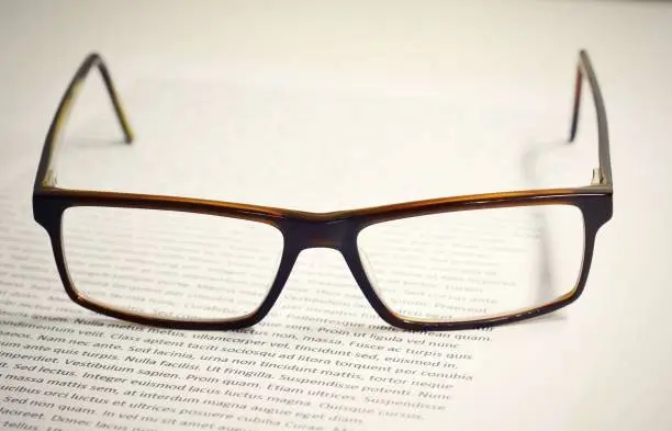 Photo of Eyeglasses on paper with lorem ipsum