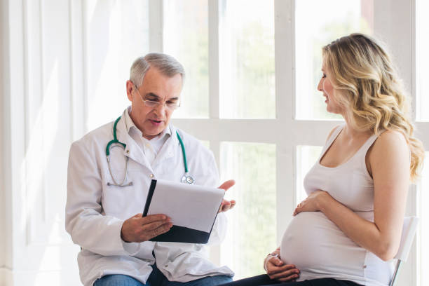 istock Pregnant woman visiting experienced doctor 1307879681