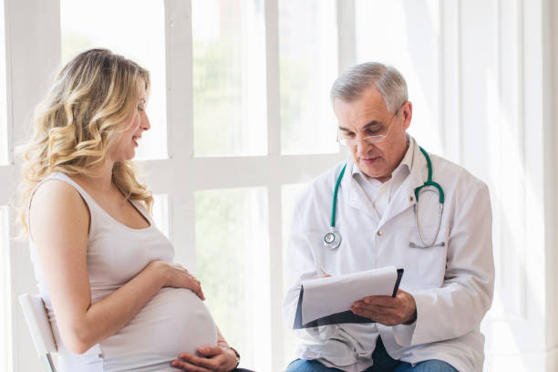 istock Pregnant woman visiting experienced doctor 1307879702