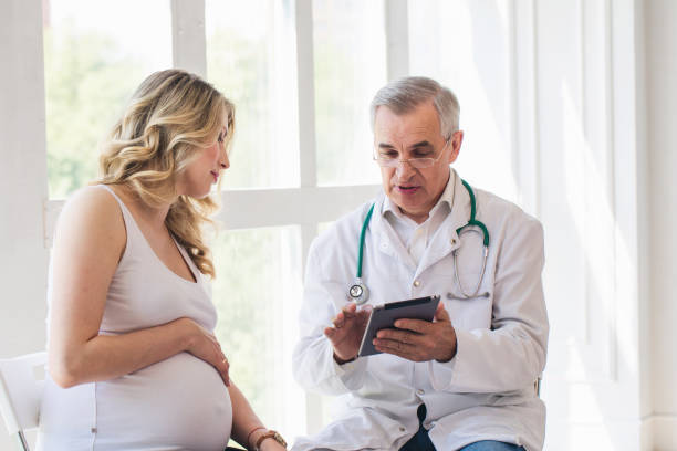 istock Pregnant woman visiting experienced doctor 1307879727