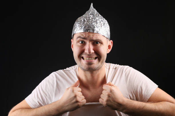 istock Crazy man in aluminum foil cap on black background 1307879930