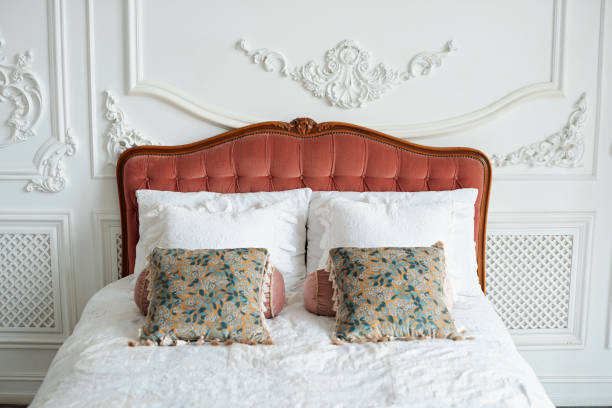 istock Luxury rich bedroom interior in light colors. Big comfortable double royal bed with different pillows in elegant classic interior. 1307882376