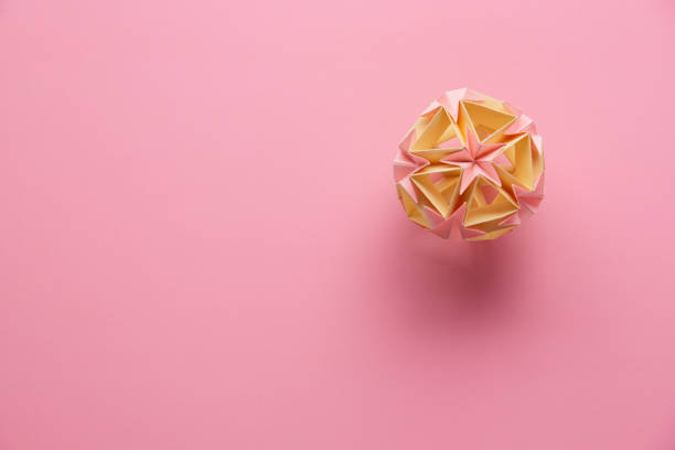 multicolorâ handmade modularâ origami ball or kusudama isolated on pink background. visual art, geometry, art of paper folding, paper crafts. top view, close up, selective focus, copy space. - kusudama imagens e fotografias de stock