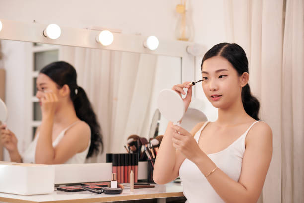 istock Young beautiful woman making make-up near mirror 1307882547