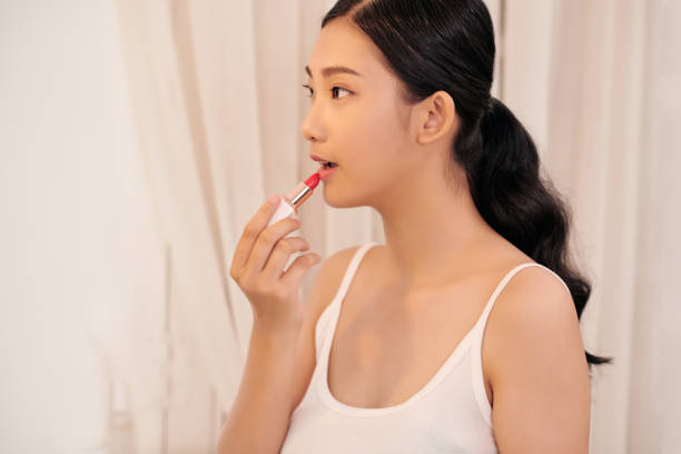 istock woman applying make up for a evening date in front of a mirror. Focus on her reflection 1307882586