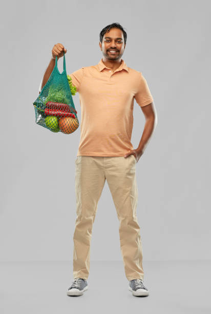 istock happy indian man with food in reusable net tote 1307886830