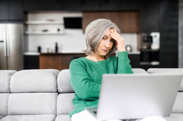 istock Mature senior woman using a laptop at home 1307887852