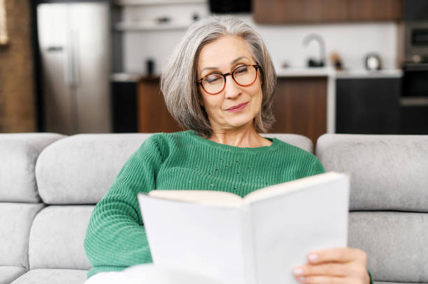 istock Mature senior woman reading a book 1307887928