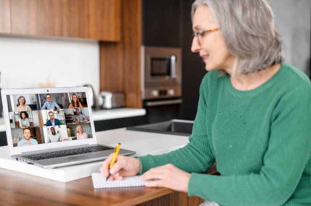 зрелая старшая женщина, используя ноутбук для видеозвонка - telephone conference call old business стоковые фото и изображения