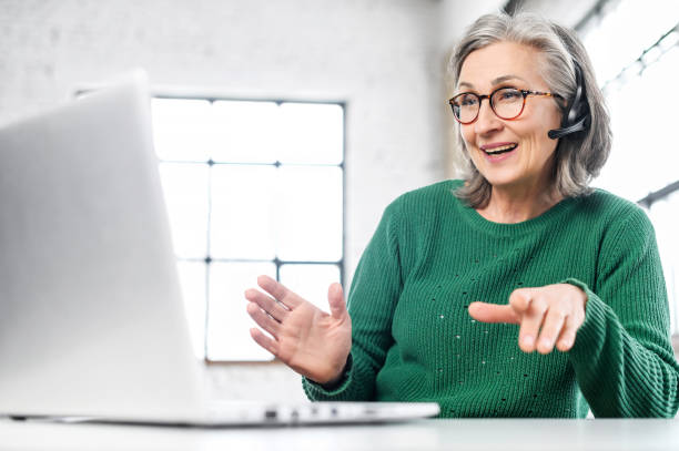 istock Mature senior woman using a headset 1307888037