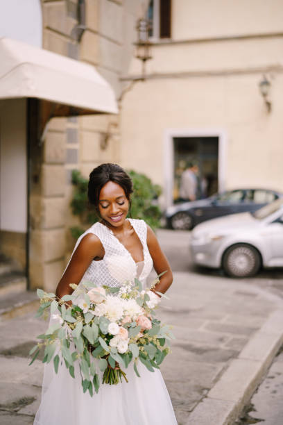 istock Smiling Bride Holding Bouquet While Standing On Road 1307891489