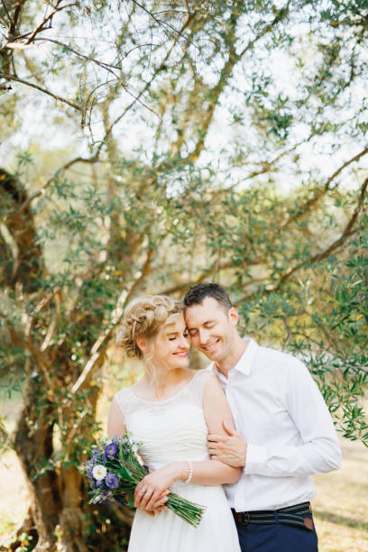 istock Couple Embracing While Holding Bouquet Outdoors 1307891565