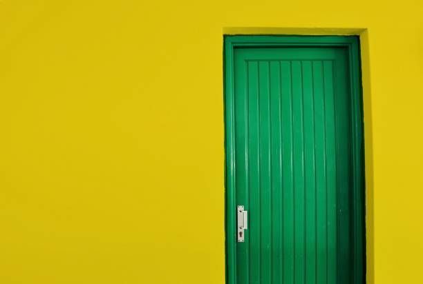 istock Yellow exterior wall and green door 1307896528