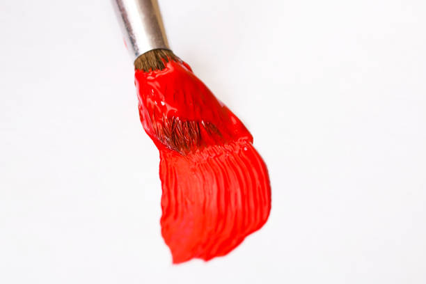 istock Brush with red paint on sheet of paper 1307897539
