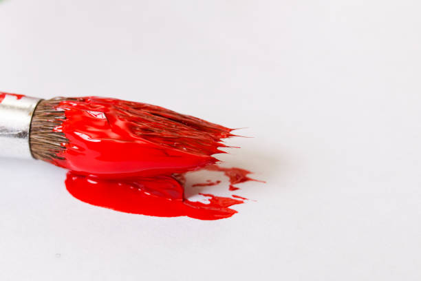 istock Brush with red paint on sheet of paper 1307897612