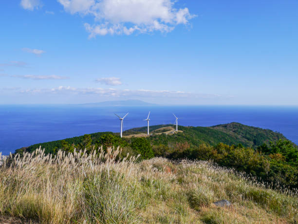 Wind Power Station Wind power station on a hill with a mountain and sea view. climate justice photos stock pictures, royalty-free photos & images