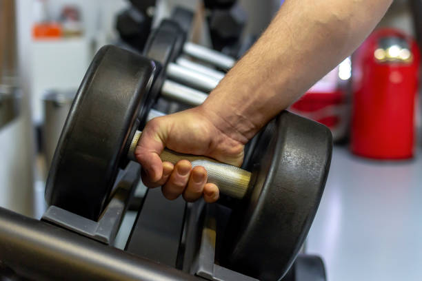 istock Unrecognizable man taking dumbbells in a gym. 1307898128