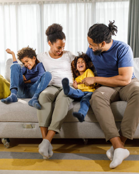 istock Happy black family having fun on sofa at home. 1307898140