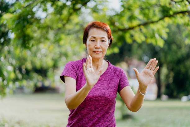 istock Senior Asian woman practicing Tai Chi at public park 1307898187