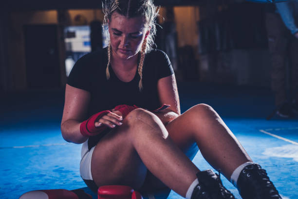 istock Female boxer wrapping her hands before a sports training 1307899132