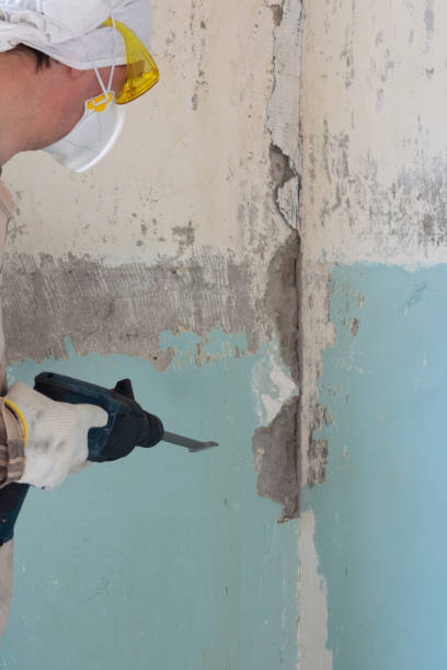 istock Worker removes old paint from a concrete wall 1307900495