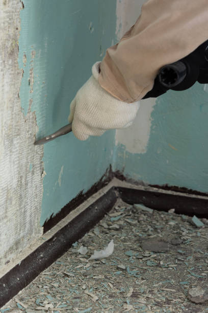 istock Worker removes old paint from a concrete wall 1307900497