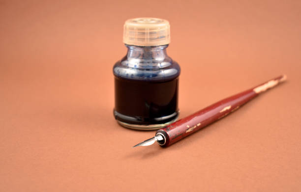 Old inkwell with pen isolated on a brown background with copy space for text