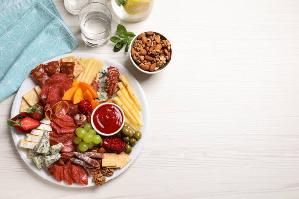 istock Plate of different appetizers with dip sauce on white wooden table, flat lay. Space for text 1307901022