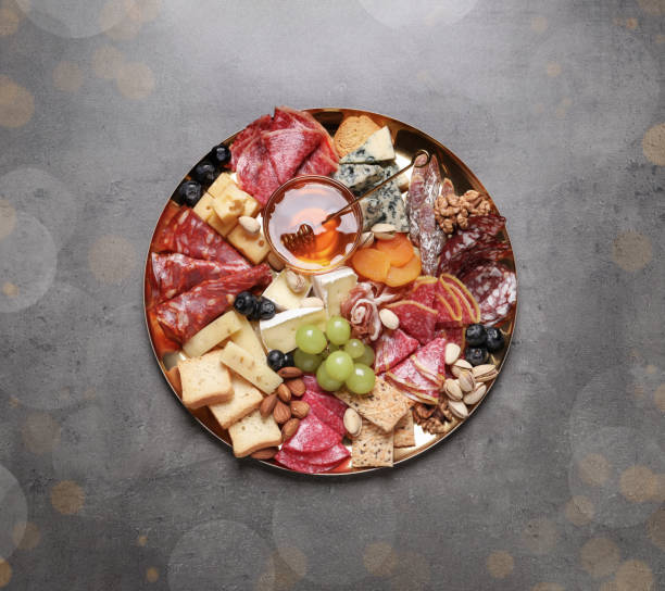 istock Plate of different appetizers with honey on grey table, top view. Bokeh effect 1307901584