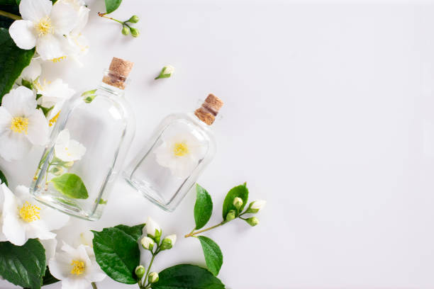istock Perfumed jasmine oil in transparent bottles on a white background with copy space. 1307902077
