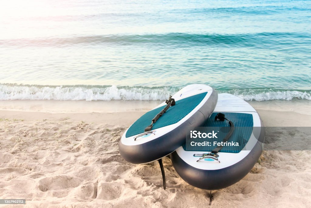 Sup boards on the beach by the water. Paddleboard Stock Photo