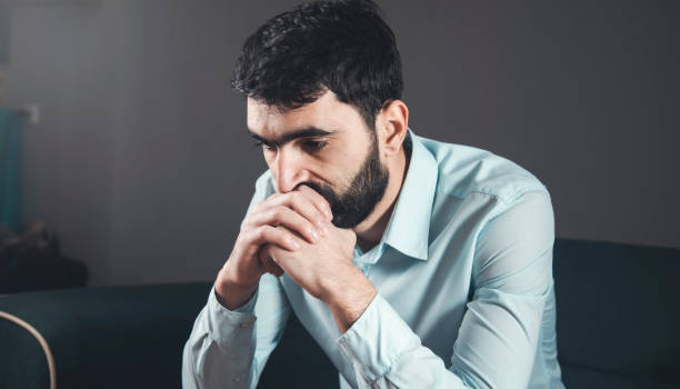 istock Sad unhappy man sitting on the sofa 1307905560