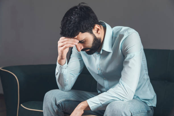 istock Sad unhappy man sitting on the sofa 1307905566