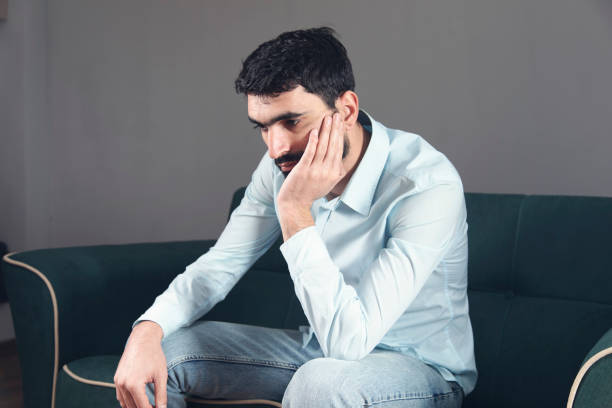 istock Sad unhappy man sitting on the sofa 1307905575