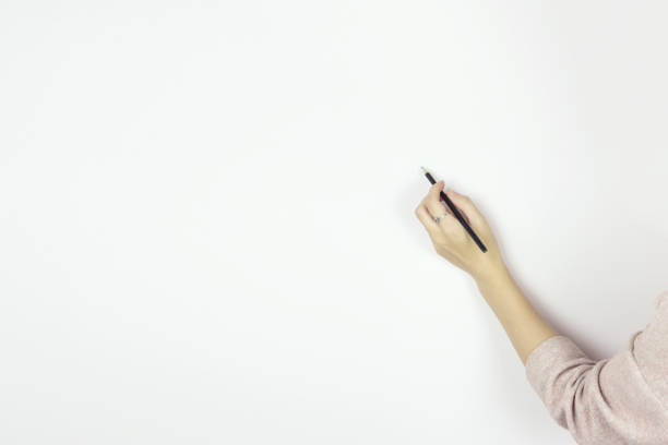 istock Hand holding wooden pencil starting to draw on Blank White Wall, Copy space. 1307910064