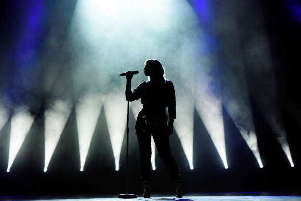 istock Vocalist singing to microphone. Singer in silhouette 1307912456