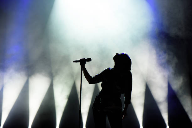 istock Vocalist singing to microphone. Singer in silhouette 1307912472