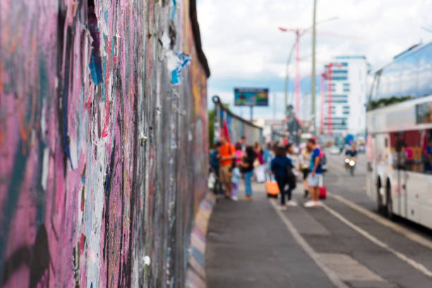 touristen an der berliner mauer. berlin, deutschland. east side gallery, berliner mauerteil - west berlin stock-fotos und bilder