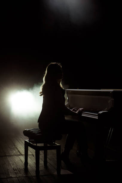 istock Female keyboards player on stage during concert, backlight 1307912571