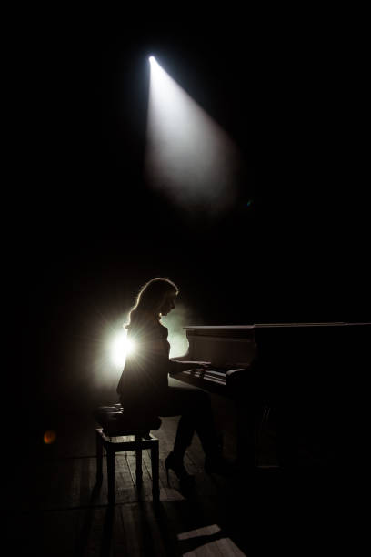 istock Female keyboards player on stage during concert, backlight 1307912578