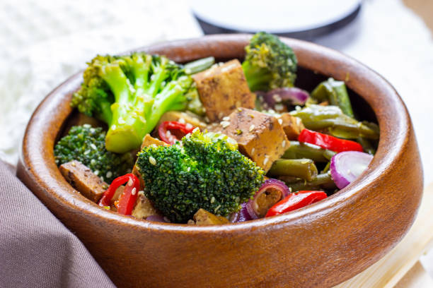 hausgemachter vegetarischer gebratener tofu mit gemüse (brokkoli, pfeffer, zwiebeln und grüne bohnen) in der holzschüssel - tofu chinese cuisine vegetarian food broccoli stock-fotos und bilder