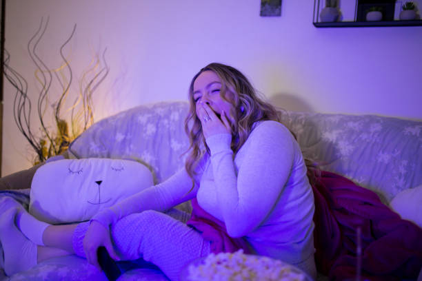 istock Beautiful young female watching boring television content and feeling sleepy 1307914862