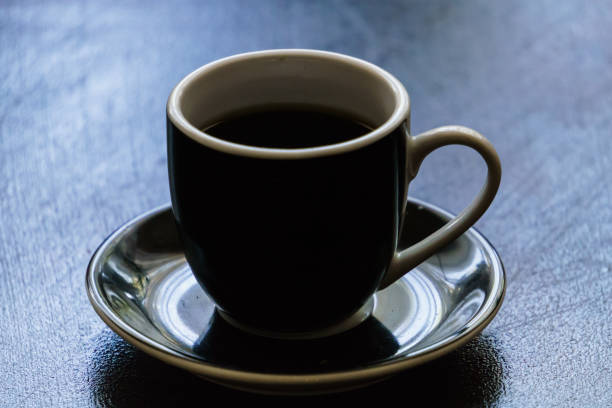 istock Black ceramic earthenware coffee cup on a saucer on a dark clean table. 1307915035